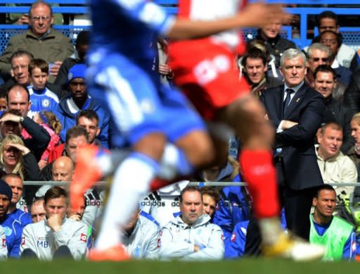 Queens Park Rangers' Mark Hughes (R) watches the game against Chelsea during the English Premier League football match between Chelsea and QPR at Stamford Bridge in London. Chelsea's Fernando Torres scored a hat-trick in the match and Chelsea won the game 6-1