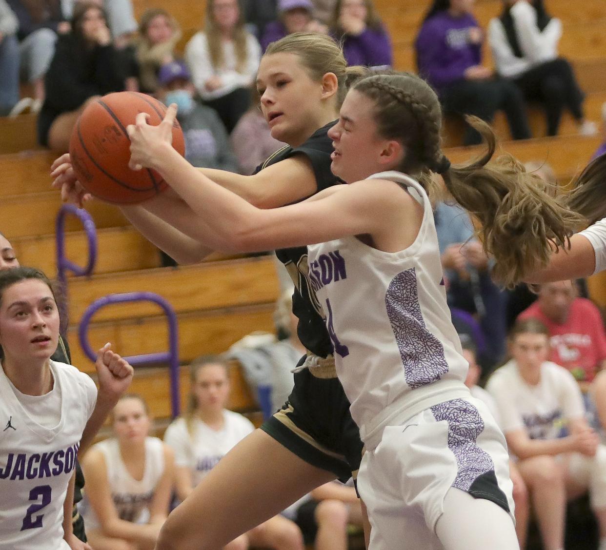 GlenOak's Kaitlyn Salmons, left, and Jackson's Madison Lepley go after a rebound, Friday, Dec. 22, 2023.