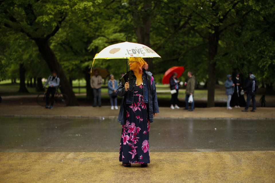 A woman holds an umbrella prior to a protest against COVID-19 restriction measures at the Bois de la Cambre park in Brussels, Saturday, May 15, 2021. (AP Photo/Francisco Seco)