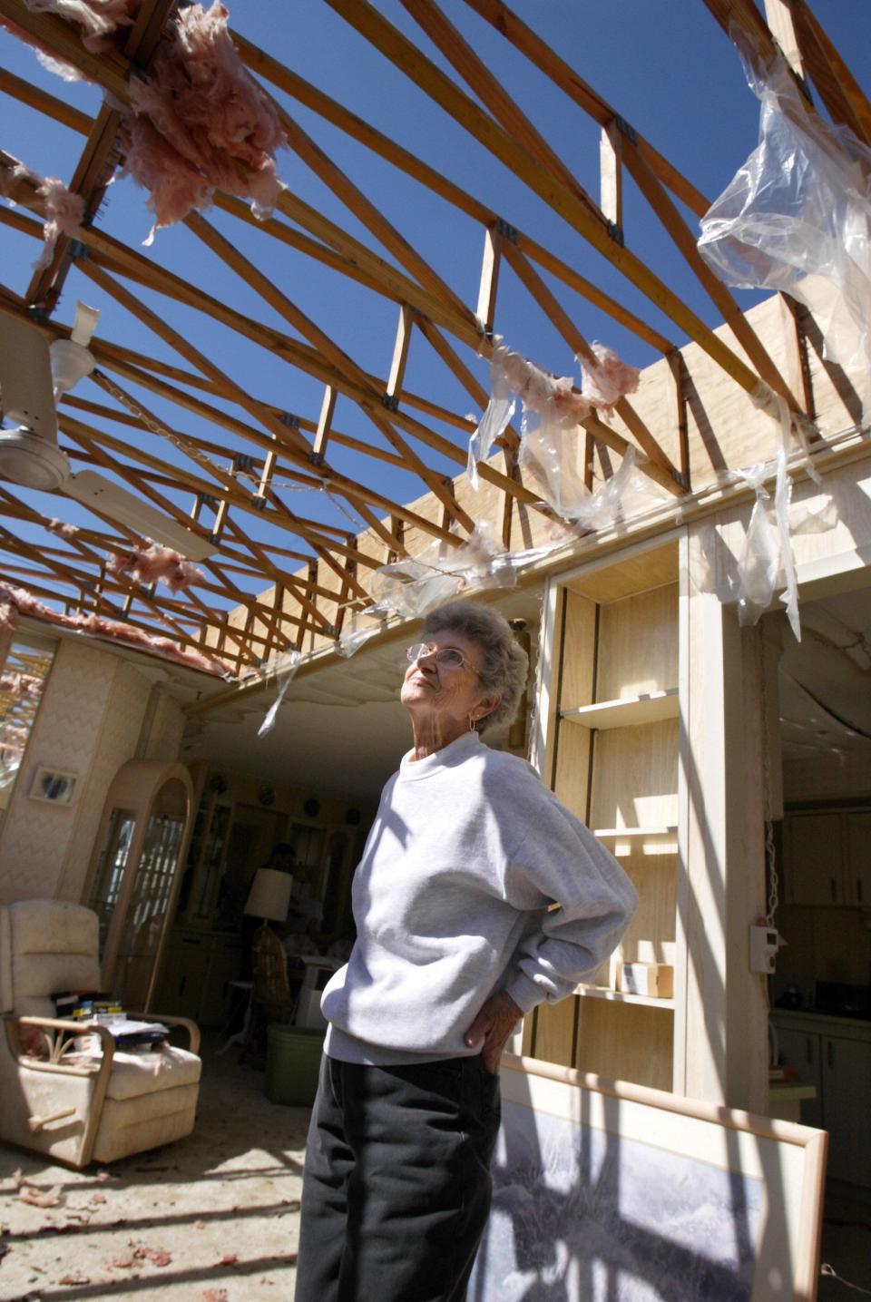 In this 2005 photo, a homeowner inspects work to replace a roof after Hurricane Wilma. Roof repairs were a high-priority item in the insurance special session in Tallahassee.