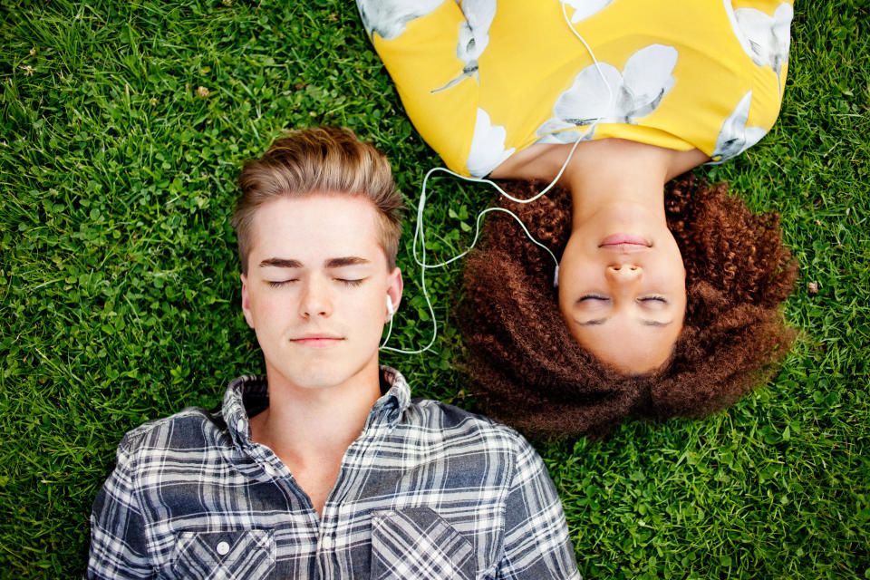 Young couple listening to and sharing music.