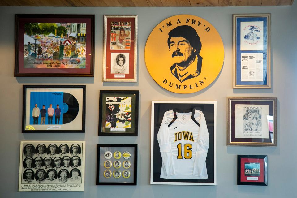 Memorabilia from Iowa sports teams and items featuring Coralville natives are displayed on a wall during the grand opening for a Raising Cane's Chicken Fingers restaurant Tuesday at 2800 Commerce Drive in Coralville.
