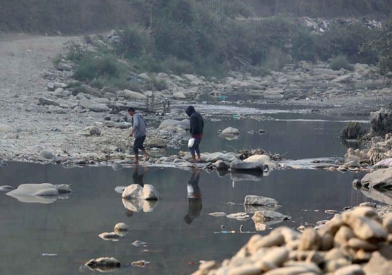 FILE PHOTO: People cross the Tiau river which marks the India-Myanmar border at Zokhawthar village