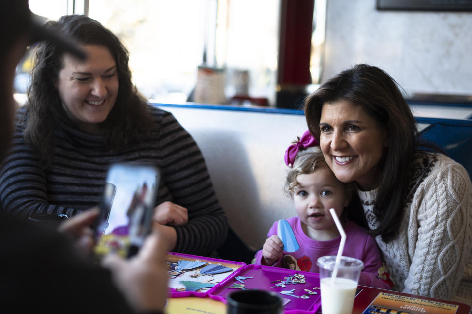 Katelyn Teal, left, looks on as Republican presidential candidate former UN Ambassador Nikki Haley, right, meets with Teal's daughter Bristol, 2, during a campaign stop at Mary Ann's Diner in Derry, N.H., Sunday, Jan. 21, 2024. (AP Photo/Matt Rourke)