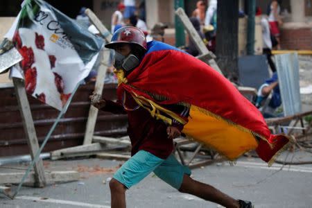 A demonstrator runs away while clashing with riot security forces during a strike called to protest against Venezuelan President Nicolas Maduro's government in Caracas, Venezuela, July 20, 2017. REUTERS/Carlos Garcia Rawlins