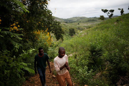 Boys walk along a trail, that was used in the past by terrain vehicles connecting with Bois Negresse, on the outskirts of Boucan Ferdinand, Haiti, October 10, 2018. REUTERS/Andres Martinez Casares