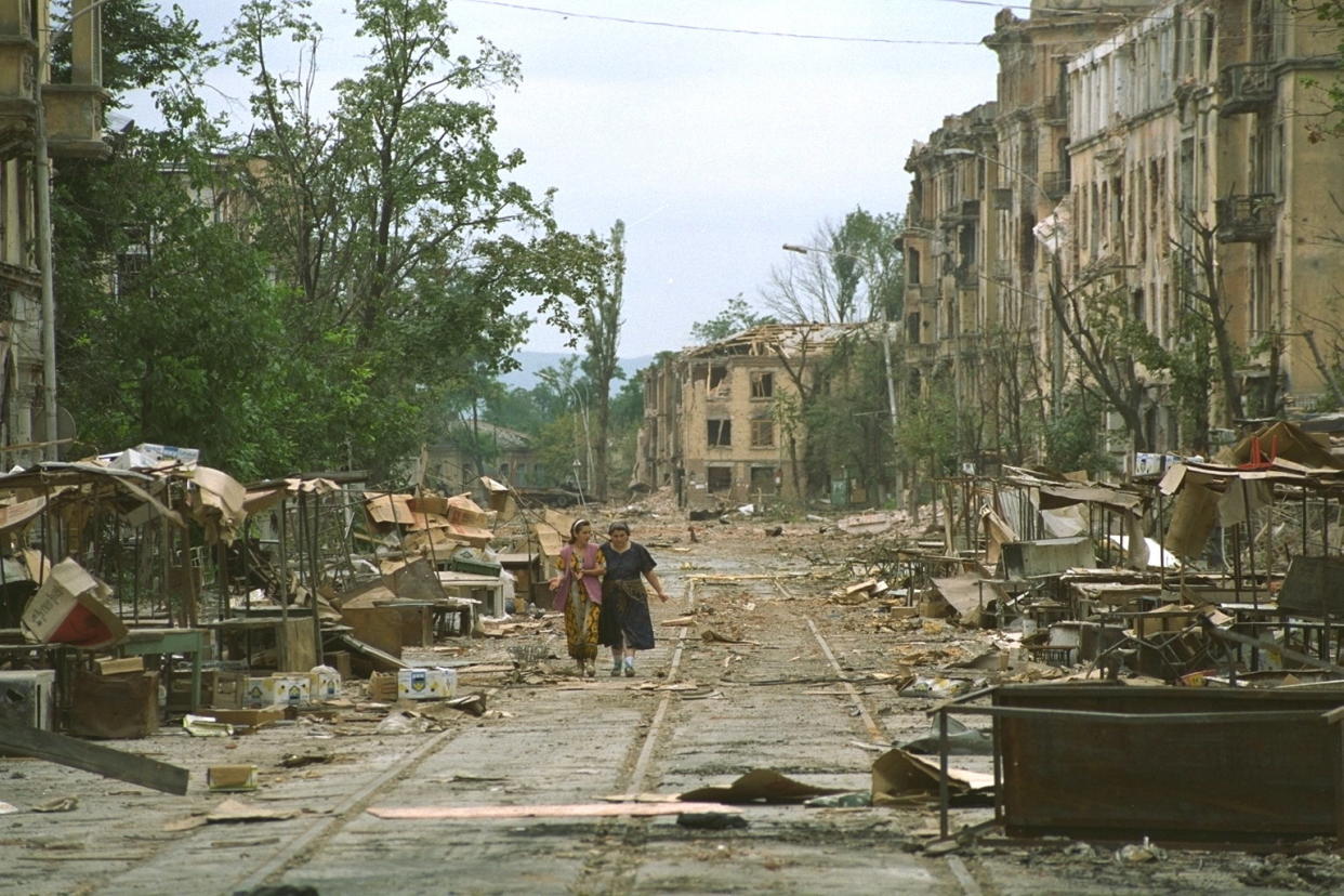 Women walk down a deserted street in war-torn Grozny, Chechnya.