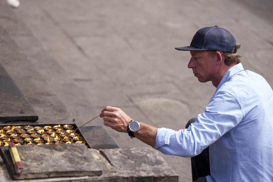 Partner Jim Morrison lights butter lamps during the funeral of famed American extreme skier Hilaree Nelson in Kathmandu, Nepal, Sunday, Oct.2, 2022. Nelson had died last week on Mount Manaslu while coming down from the top of the summit the 8,163-meter (26,775-foot) world's eighth-highest mountain. (AP Photo/Niranjan Shrestha)