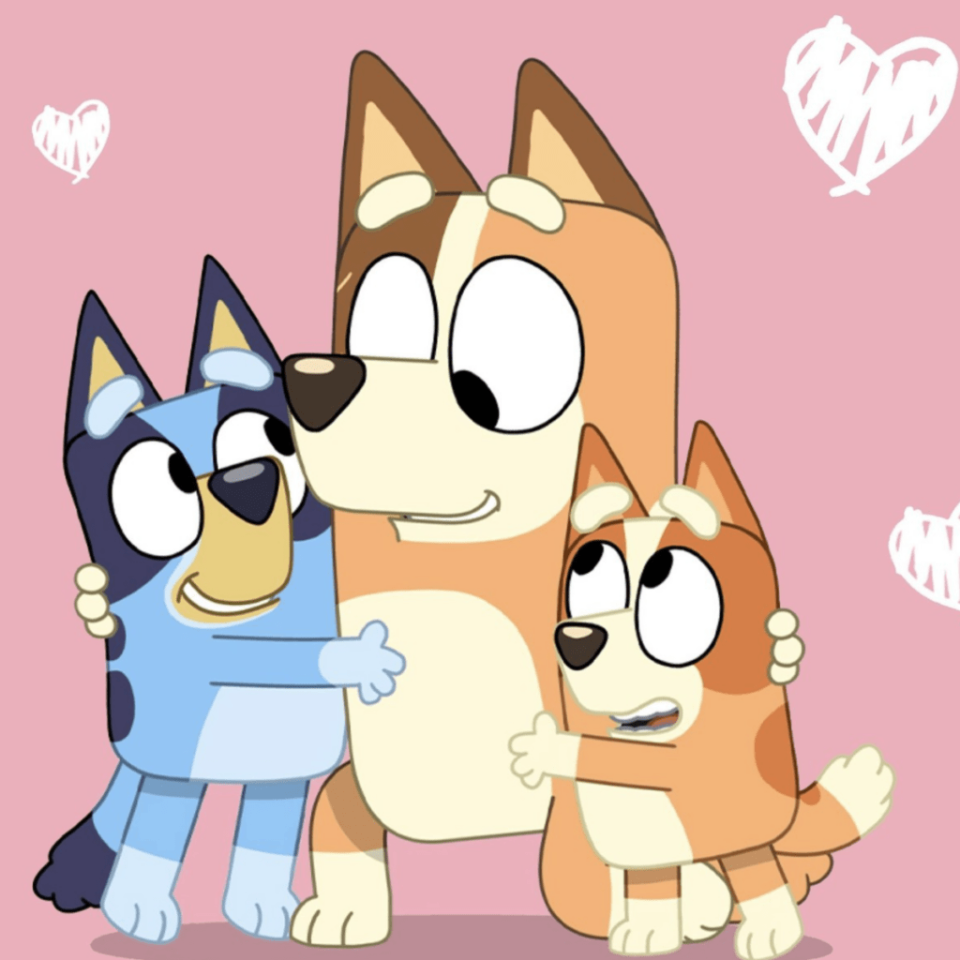 A screenshot from animated kids show "Bluey" showing kids Bluey and Bingo hugging their mom Chilli