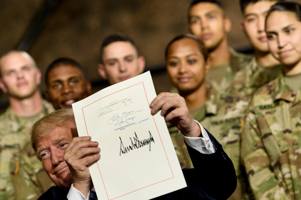 US President Donald Trump holds the John S. McCain National Defense Authorization Act for Fiscal Year 2019 after signing it at Fort Drum, New York, on August 13, 2018. (Brendan Smialowski/AFP via Getty Images)