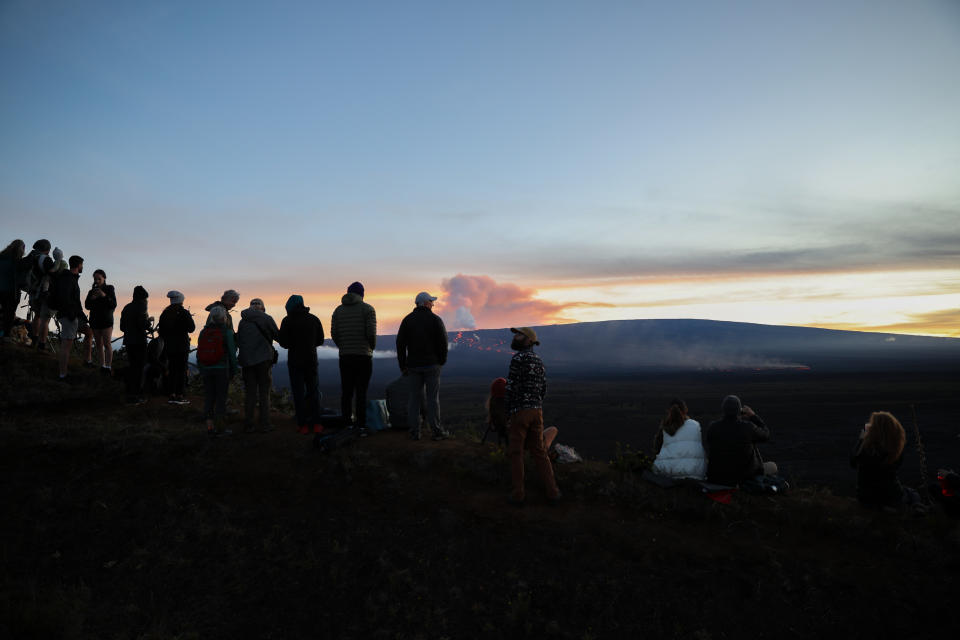 La gente y fotógrafos observan a lo lejos los ríos de lava que va dejando el Mauna Loa. (Photo by Tayfun Coskun/Anadolu Agency via Getty Images).