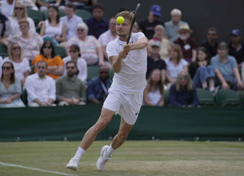 Belgium's David Goffin plays a return to Frances Tiafoe of the US in a fourth round men's singles match on day seven of the Wimbledon tennis championships in London, Sunday July 3, 2022. (AP Photo/Alastair Grant)