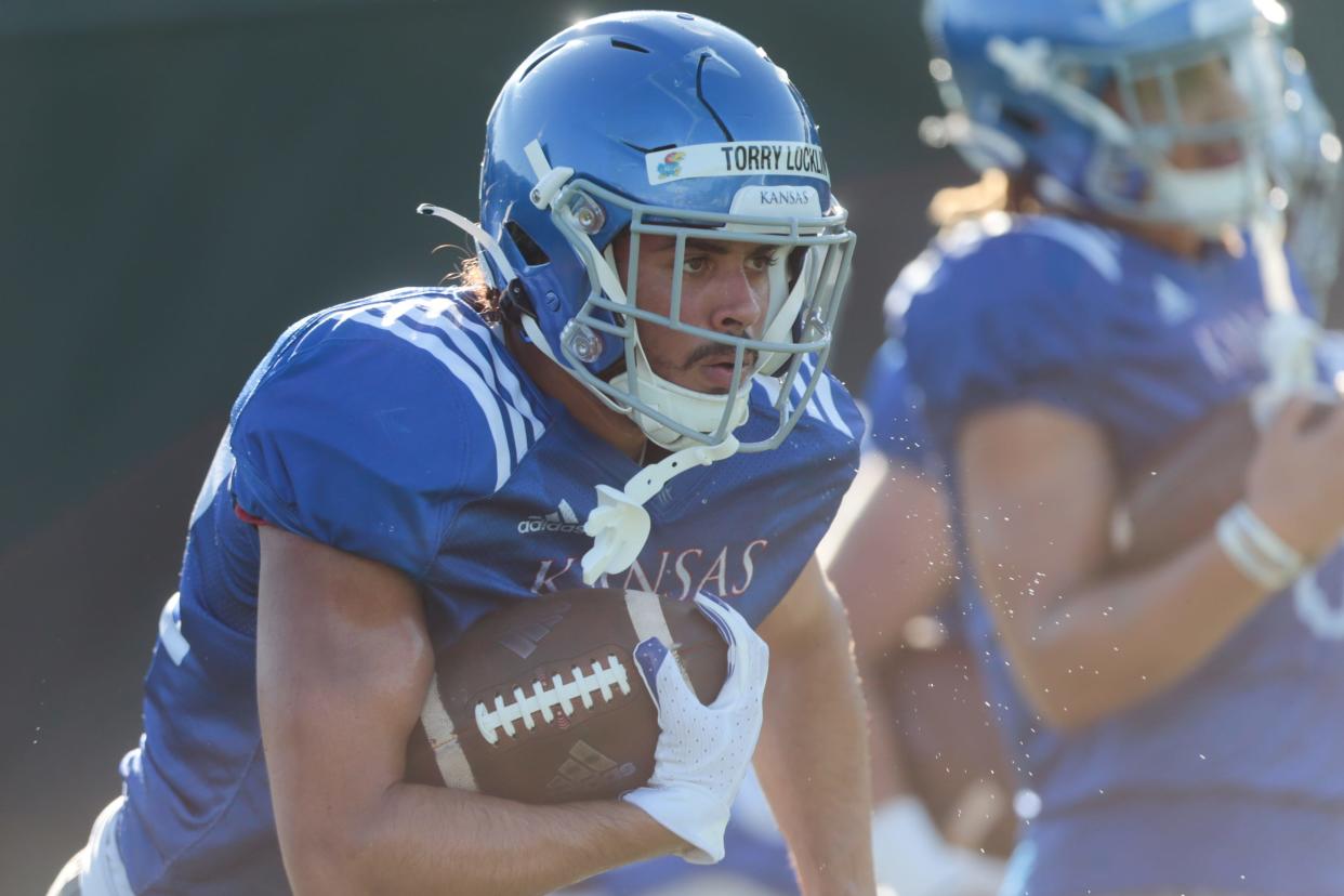 Kansas redshirt junior running back Torry Locklin (12) works through a running drill during practice Tuesday morning.