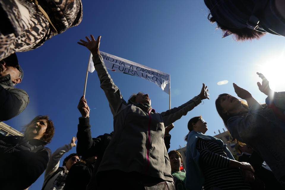 People take part in a demonstration seeking justice for police officers killed in the line of duty, in front of the La Moneda presidential palace in Santiago, Chile, Saturday, April 27, 2024. Three police officers were killed early Saturday, in Cañete, Chile's Bío Bío region. (AP Photo/Esteban Felix)