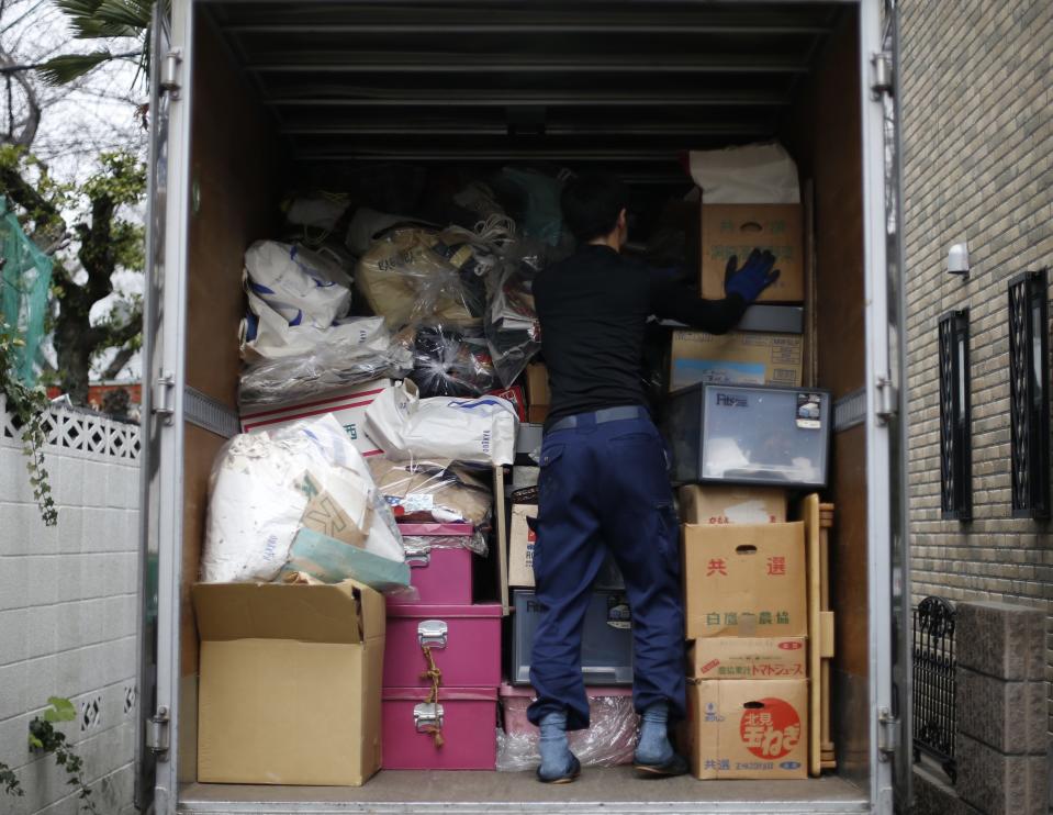 Un trabajador carga las cajas llenas de basura de un piso que acaban de limpiar en Tokio.