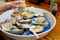 A customer at Lynn's Quality Oysters in Eastpoint, Florida, U.S., eats raw oysters from Texas at the restaurant