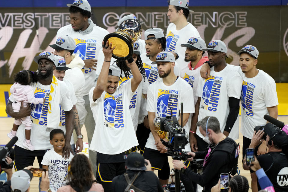 Golden State Warriors guard Jordan Poole holds up the Western Conference Finals Trophy surrounded by his teammates after they beat the Dallas Mavericks in five games to advance to the NBA Finals. (Thearon W. Henderson/Getty Images)