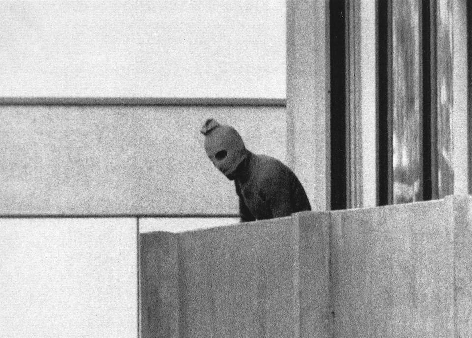 FILE - A member of the Arab Commando group which seized members of the Israeli Olympic Team at their quarters at the Olympic Village appearing with a hood over his face stands on the balcony of the building where the commandos held members of the Israeli team hostage in Munich, Sept. 5, 1972. The families of 11 Israeli athletes killed by Palestinian attackers at the 1972 Summer Olympics in Munich and the German government are close to reaching a deal over the long-disputed amount of the compensation. (AP Photo/Kurt Strumpf, File)