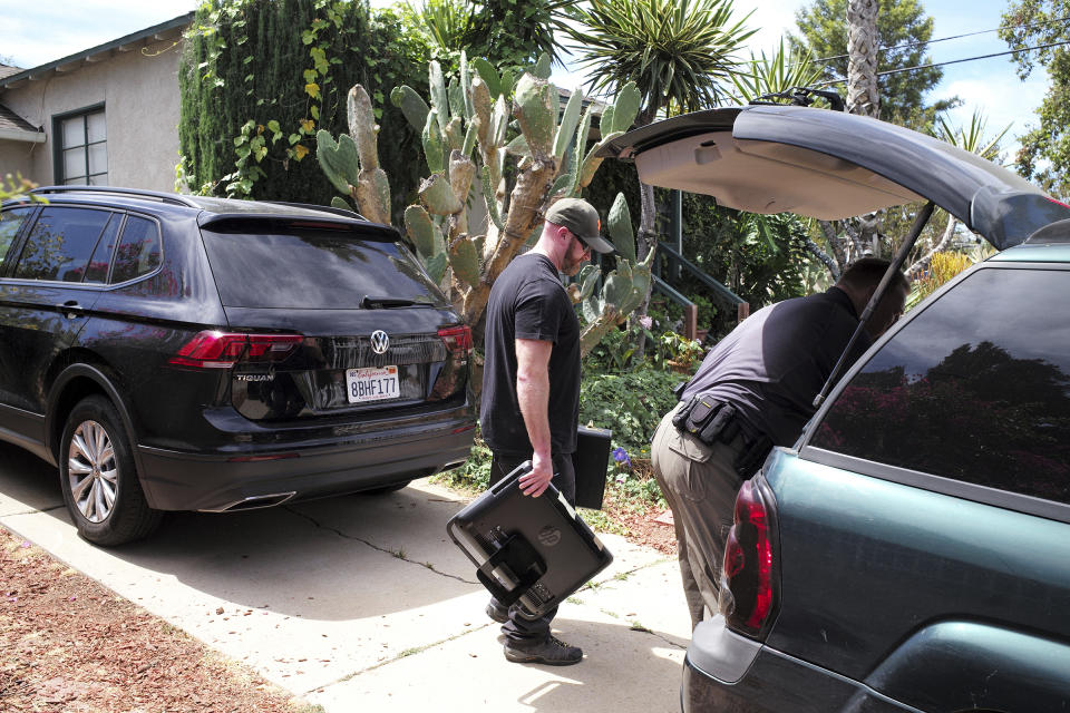 FBI agents remove evidence from the home of Robert Chain in the Encino section of Los Angeles on Thursday, Aug. 30, 2018. Chain, who was upset about The Boston Globe's coordinated editorial response to President Donald Trump's attacks on the news media, was arrested Thursday for threatening to travel to the newspaper's offices and kill journalists, whom he called the "enemy of the people," federal prosecutors said. (David Crane/Los Angeles Daily News via AP)