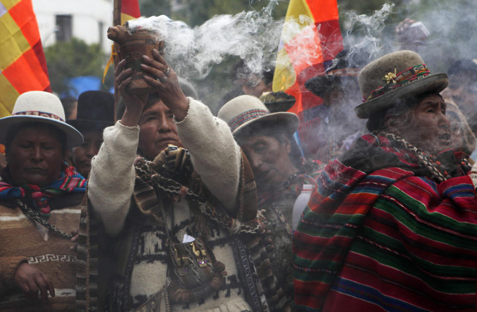 Aymara Indian women celebrate the launch of the country's first telecommunications satellite with indigenous rituals dedicated to Pachamama, or Mother Earth in La Paz, Bolivia, Friday,  Dec. 20, 2013. Hundreds of people gathered in the Bolivian capital to watch the China launch of the satellite named after Tupac Katari, an indigenous Aymara hero who led 18th century resistance to Spanish colonizers, on large television screens erected by the government. (AP Photo/Juan Karita)