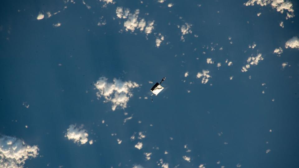 a white bag floats in space above the Earth