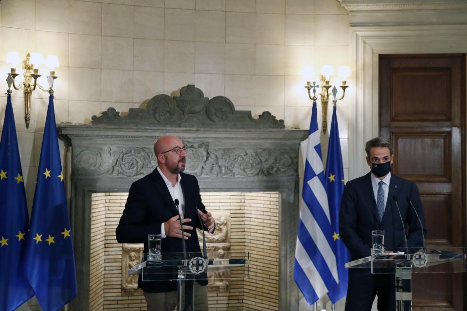 European Council President Charles Michel, left, makes statements after his meeting with Greece's Prime Minister Kyriakos Mitsotakis at Maximos Mansion in Athens, Tuesday, Sept. 15, 2020. Michel will visit Lesbos later today as Greece's migration minister says the government will use force if necessary to move homeless migrants to a new facility on the island after thousands of people were left without shelter by fires last week at an overcrowded refugee camp. (AP Photo/Thanassis Stavrakis)
