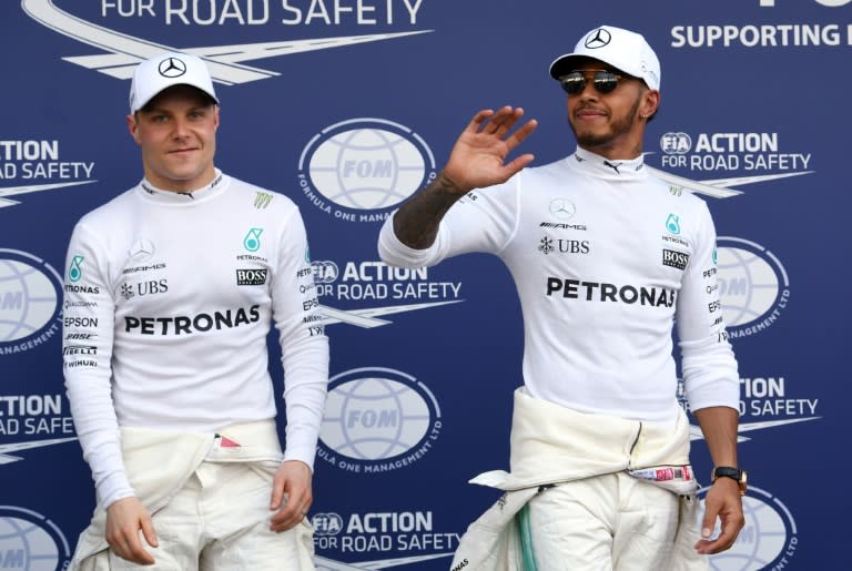 Mercedes' British driver Lewis Hamilton (R) and Finnish teammate Valtteri Bottas celebrate after the qualifying session at the Formula One Australian Grand Prix in Melbourne on March 25, 2017