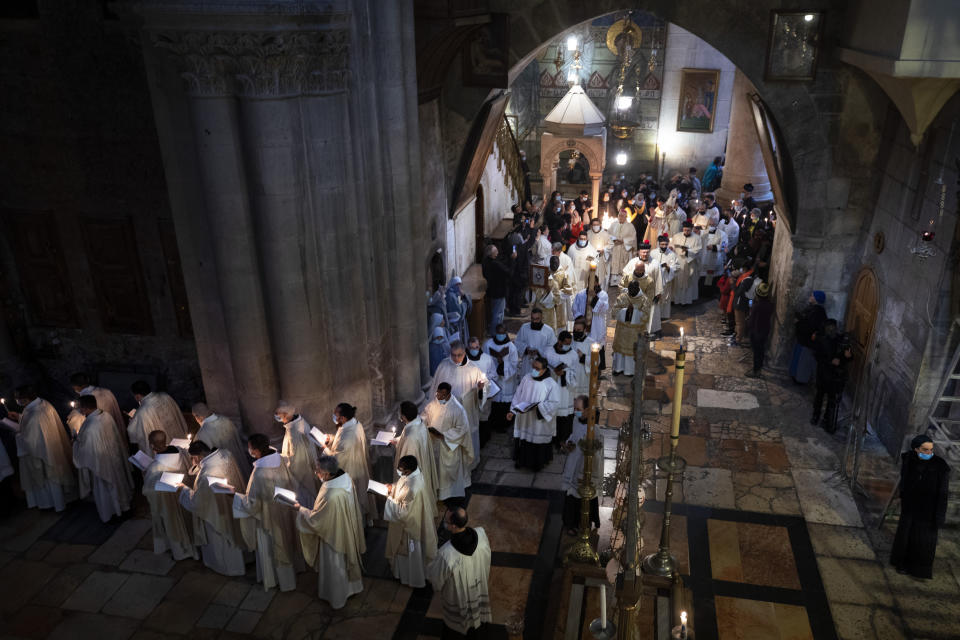 Priests participate in the Easter Sunday Mass led by the Latin Patriarch at the Church of the Holy Sepulchre, where many Christians believe Jesus was crucified, buried and rose from the dead, in the Old City of Jerusalem, Sunday, April 4, 2021. (AP Photo/Oded Balilty)