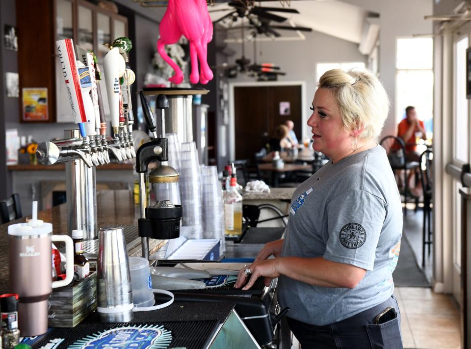 Caitlin Evans, owner of Dockside, works behind the bar Thursday, July 27, 2023, in Pocomoke City, Maryland.