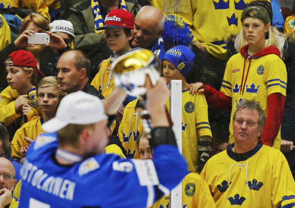 Swedish fans watch Finland's Rasmus Ristolainen celebrates with the trophy after defeating Sweden in overtime of their IIHF World Junior Championship gold medal ice hockey game in Malmo, Sweden, January 5, 2014. REUTERS/Alexander Demianchuk (SWEDEN - Tags: SPORT ICE HOCKEY)
