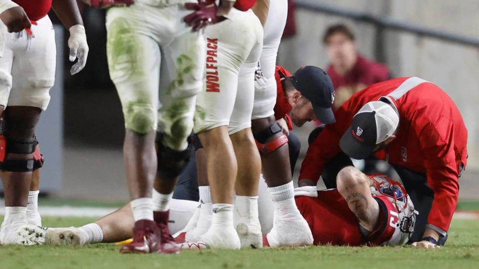 N.C. State quarterback Devin Leary (13) is checked on after being injured during the second half of N.C. State’s game against Florida State at Carter-Finley Stadium in Raleigh, N.C., Saturday, Oct. 8, 2022.