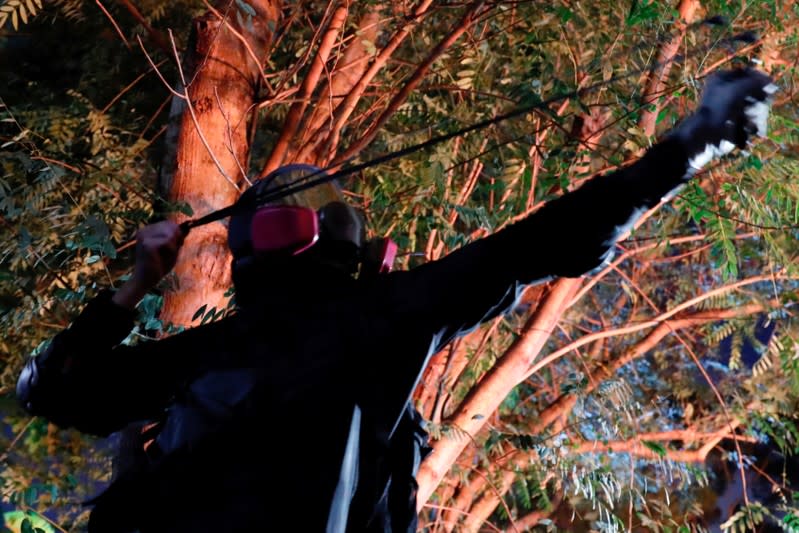 An anti-government protester uses a slingshot during a standoff with riot police at the Chinese University of Hong Kong, Hong Kong