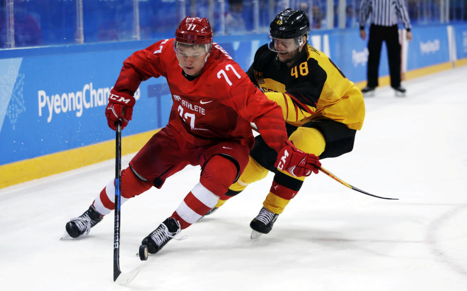 FILE - Russian athlete Kirill Kaprizov (77) tries to keep Frank Hordler (48), of Germany, away from the puck during the second period of the men's gold medal hockey game at the 2018 Winter Olympics, Sunday, Feb. 25, 2018, in Gangneung, South Korea. The 2018 Olympics without NHL talent offered a glimpse of things to come for players who hadn't yet reached the best hockey league in the world. (AP Photo/Julio Cortez, File)