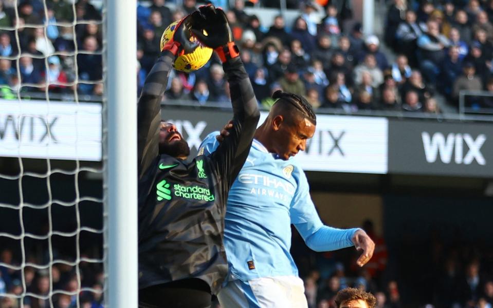 Manuel Akanji challenges Alisson for the ball