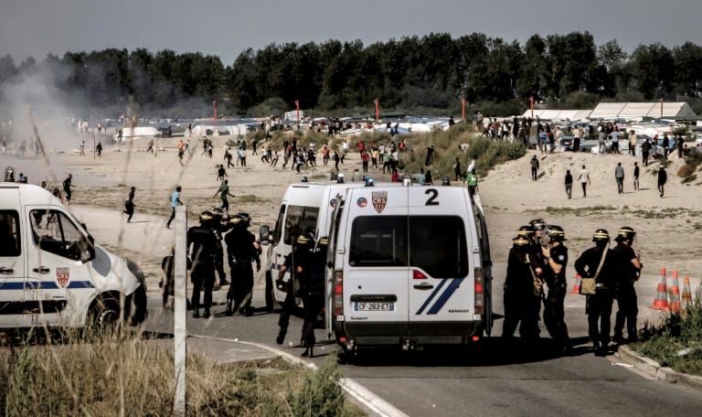 Riot police disperse migrants trying to get into trucks heading to Great Britain, on September 21, 2016 in Calais