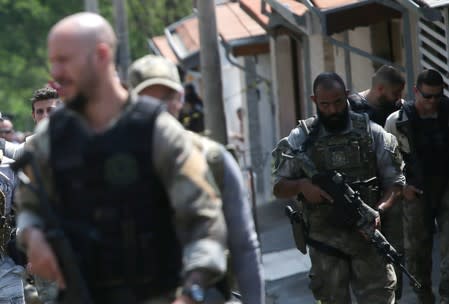 Federal police officers are seen near a site where an armed gang holds people hostage after they robbed a securities company at the Viracopos airpoart freight terminal, in Campinas