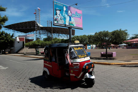 A man drives a moto-taxi past a billboard of Nicaragua's President Daniel Ortega in Managua, Nicaragua September 19, 2016. REUTERS/Oswaldo Rivas