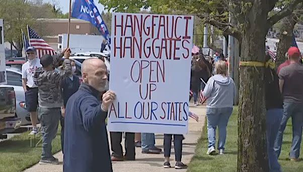 Protester holds threatening sign at Long Island protest against COVID-19 safety precautions. 