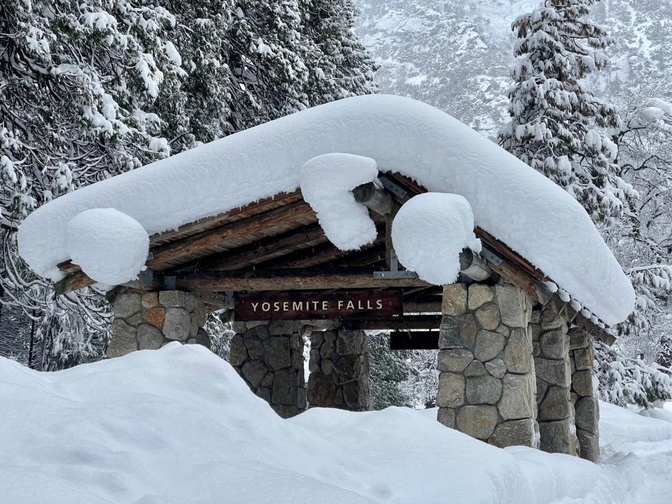 In this photo provided by the National Park Service, a structure at Yosemite Falls in Yosemite National Park, Calif., is covered in snow Tuesday, Feb. 28, 2023. Yosemite National Park, closed since Saturday because of heavy, blinding snow, postponed its planned Thursday, March 2, 2023, reopening indefinitely.