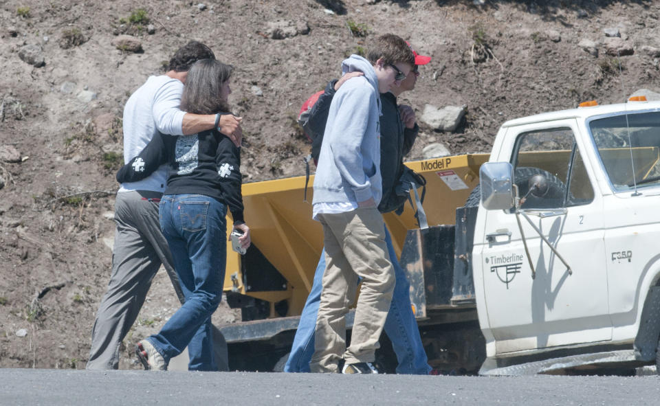 People walk away from the medical examiners truck near the maintenance buildings just below Timberline Lodge, where the body of climber Mark Cartier, who fell to his death in the upper elevations of Mount Hood, Ore was taken, Thursday, June 14, 2012. The climber was moved down the mountain by snow cat then transferred to the medical examiners truck. (AP Photo/The Oregonian, Brent Wojahn)