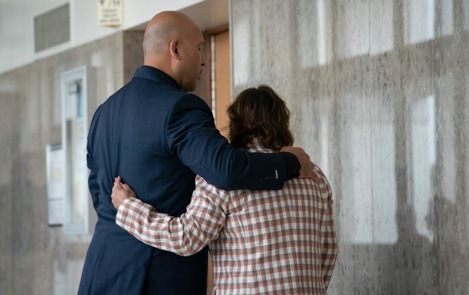 Attorney Wolfgang Mueller, left consoles Phoebe Arthur’s mom, Sandra Cunningham, in the hallway during a break as a hearing is held at the Oakland County Court House on  July 28, 2023, to determine whether Ethan Crumbley will serve a life sentence without parole for the Oxford School shootings where he murdered four students and injured seven others in the 2021 shooting massacre.