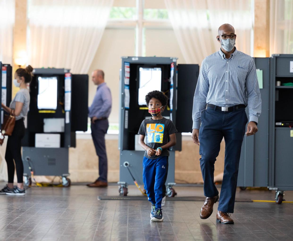 A Black man and his son leave a polling location in Atlanta after casting a vote in the Georgia primary election on May 24, 2022. <a href="https://www.gettyimages.com/detail/news-photo/voter-and-his-son-leave-the-park-tavern-polling-location-news-photo/1240876683?phrase=georgia%20voting%20%202022%20primary&adppopup=true" rel="nofollow noopener" target="_blank" data-ylk="slk:Jessica McGowan/Getty Images;elm:context_link;itc:0;sec:content-canvas" class="link ">Jessica McGowan/Getty Images</a>