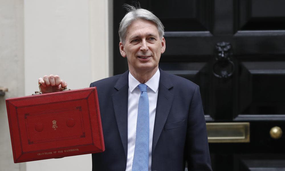 Britain’s Chancellor of the Exchequer Philip Hammond poses for the media as he holds up the traditional red dispatch box, outside his official residence 11 Downing Street, before delivering his annual budget speech to Parliament