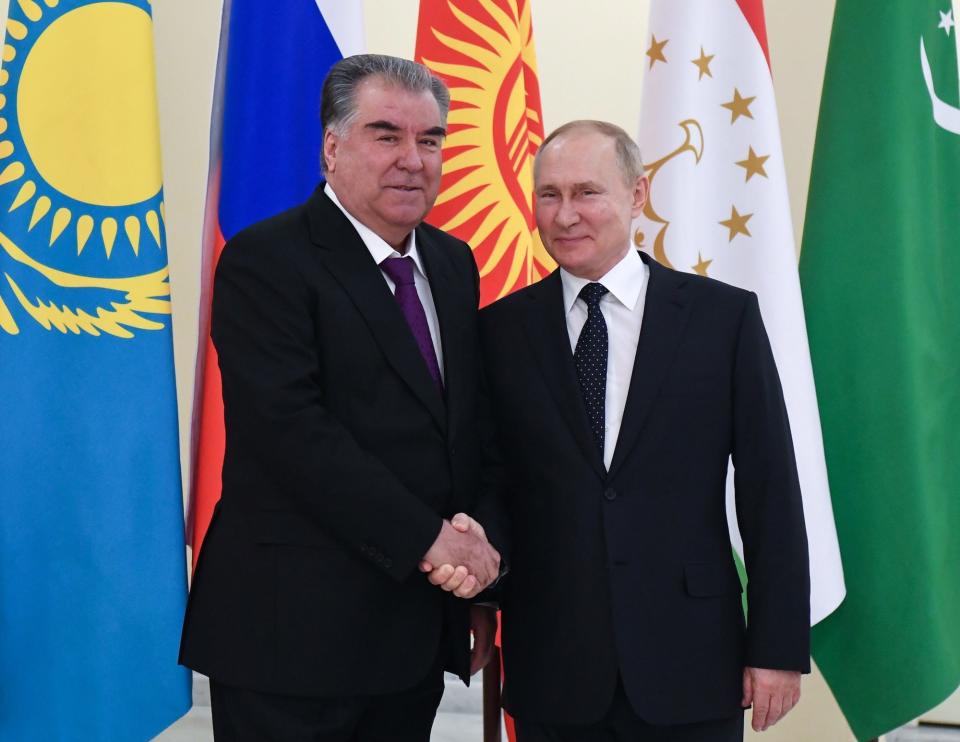 Russian President Vladimir Putin shakes hands with Tajik President Emomali Rahmon in Saint Petersburg, Russia, in December 2021.