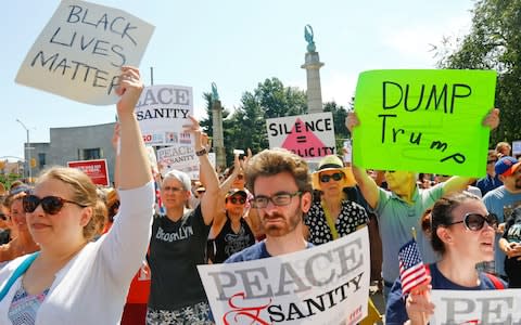 Protesters listen during a "Peace and Sanity" rally Sunday Aug. 13, 2017, in New York, as speakers address white supremacy violence in Charlottesville - Credit: Bebeto Matthews/AP