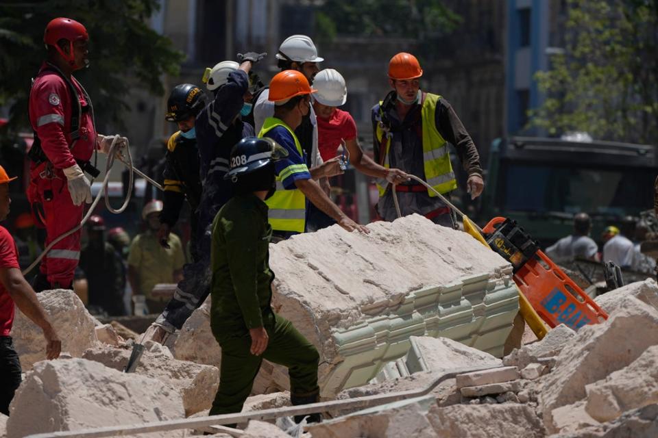 Emergency workers with a stretcher stand amid the rubble outside the five-star Hotel Saratoga after a deadly explosion in Old Havana, Cuba, Friday, May 6, 2022 (AP)