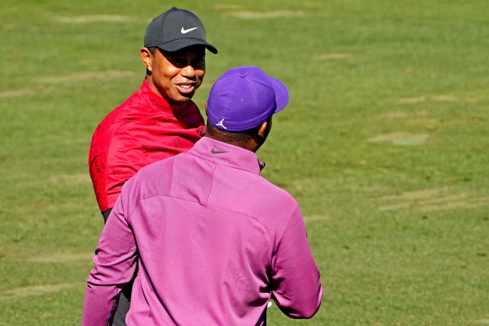 Tiger Woods talks with Harold Varner III on the practice range as he prepares to play Sunday's final round at Augusta National.