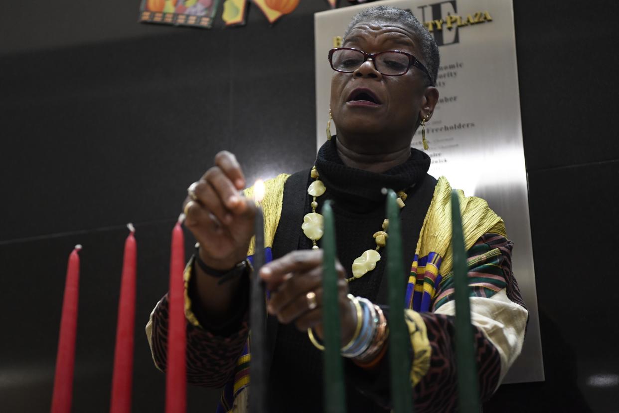 Barbara Taylor-Rosser lights the candles of the Kinara and goes over the symbols and seven principles of Kwanzaa during a ceremony at One Bergen County Plaza in Hackensack, NJ on Tuesday, December 20, 2016.