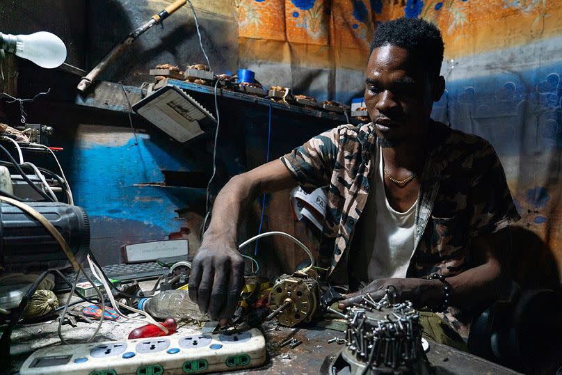 Old Fadama in Accra, Ghana, February 9, 2023. Working through the night, Latif Fuseini, a repairman, attempts to repair and reanimate end-of-life electric motors.