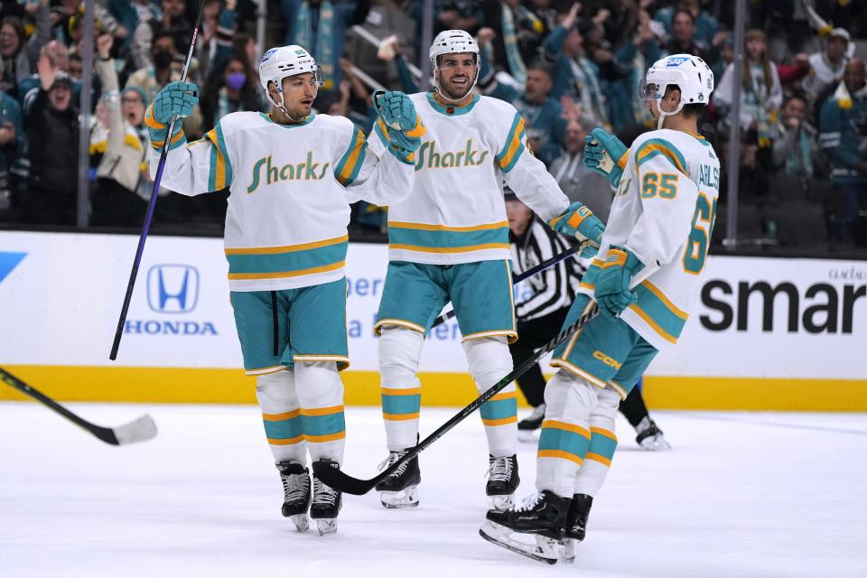 San Jose Sharks right wing Kevin Labanc, left celebrates with Erik Karlsson (65) and Jaycob Megna, center, after scoring a goal against the Los Angeles Kings during the first period Friday, Nov. 25, 2022, in San Jose, Calif.
